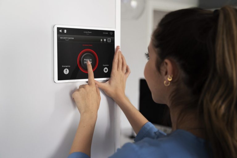 Woman using digital thermostat illustrates blog "5 Signs Your AC Needs Cleaning"