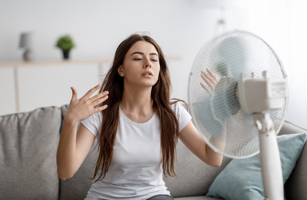 no-ac-woman-prostock-studio Woman fanning herself illustrates blog "My AC Can't Keep My House Cool. What To Do?"